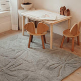 Washable wool children's rug with a colorful floral field design, featuring vibrant flowers in soft pastel tones.