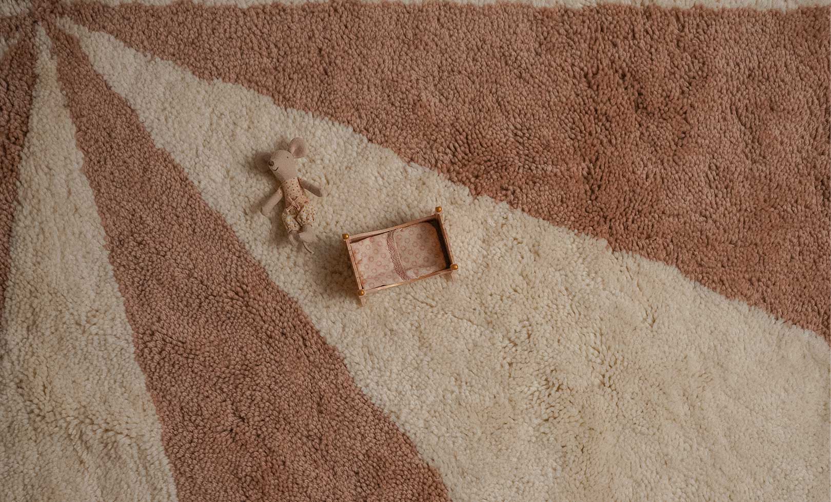 Brown toy truck and teddy bear on a pink and beige patterned nontoxic children's washable wool rug