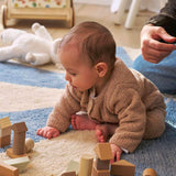 A blue wool rug with a pinwheel design, washable and child-friendly.