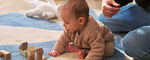 A blue wool rug with a pinwheel design, washable and child-friendly.