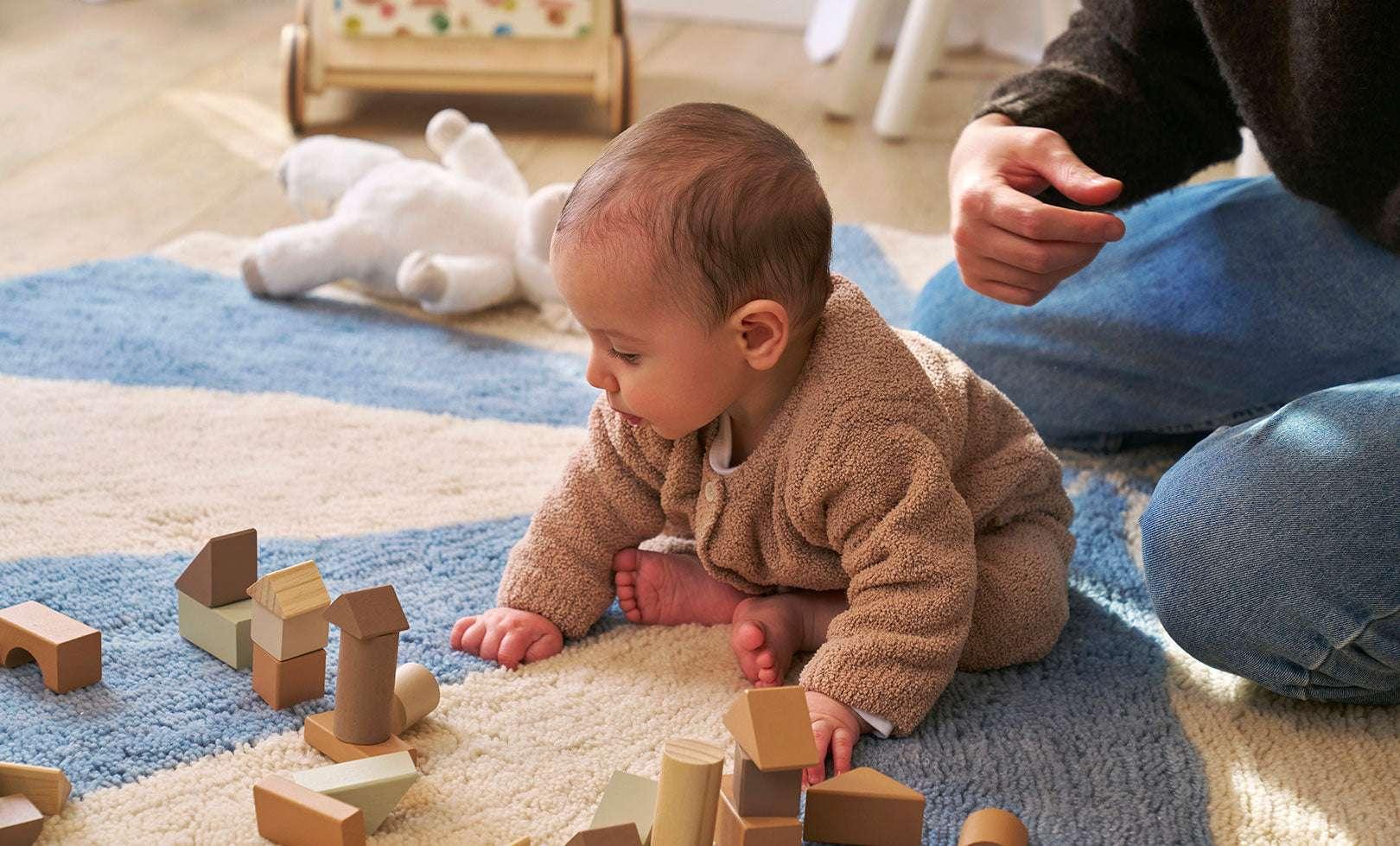 A blue wool rug with a pinwheel design, washable and child-friendly.