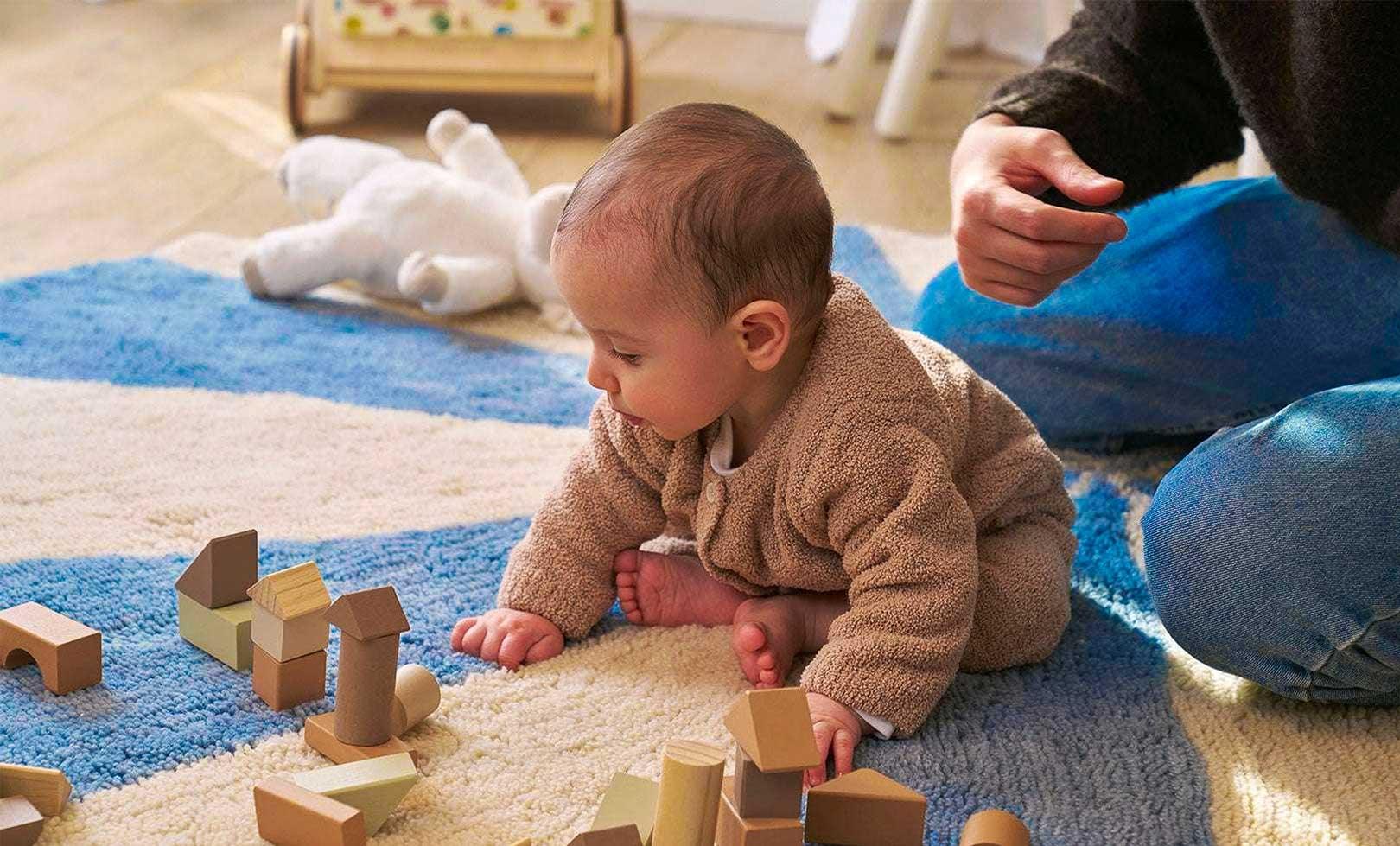 A blue wool rug with a pinwheel design, washable and child-friendly.