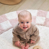 Organic washable nursery rug with a checkerboard pattern in soft, muted tones, designed for safety and comfort.
