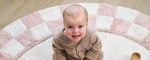 Organic washable nursery rug with a checkerboard pattern in soft, muted tones, designed for safety and comfort.