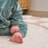 Chic pink checker rug made from organic fibers, combining soft hues with child-safe, machine-washable practicality.