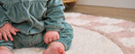 Chic pink checker rug made from organic fibers, combining soft hues with child-safe, machine-washable practicality.