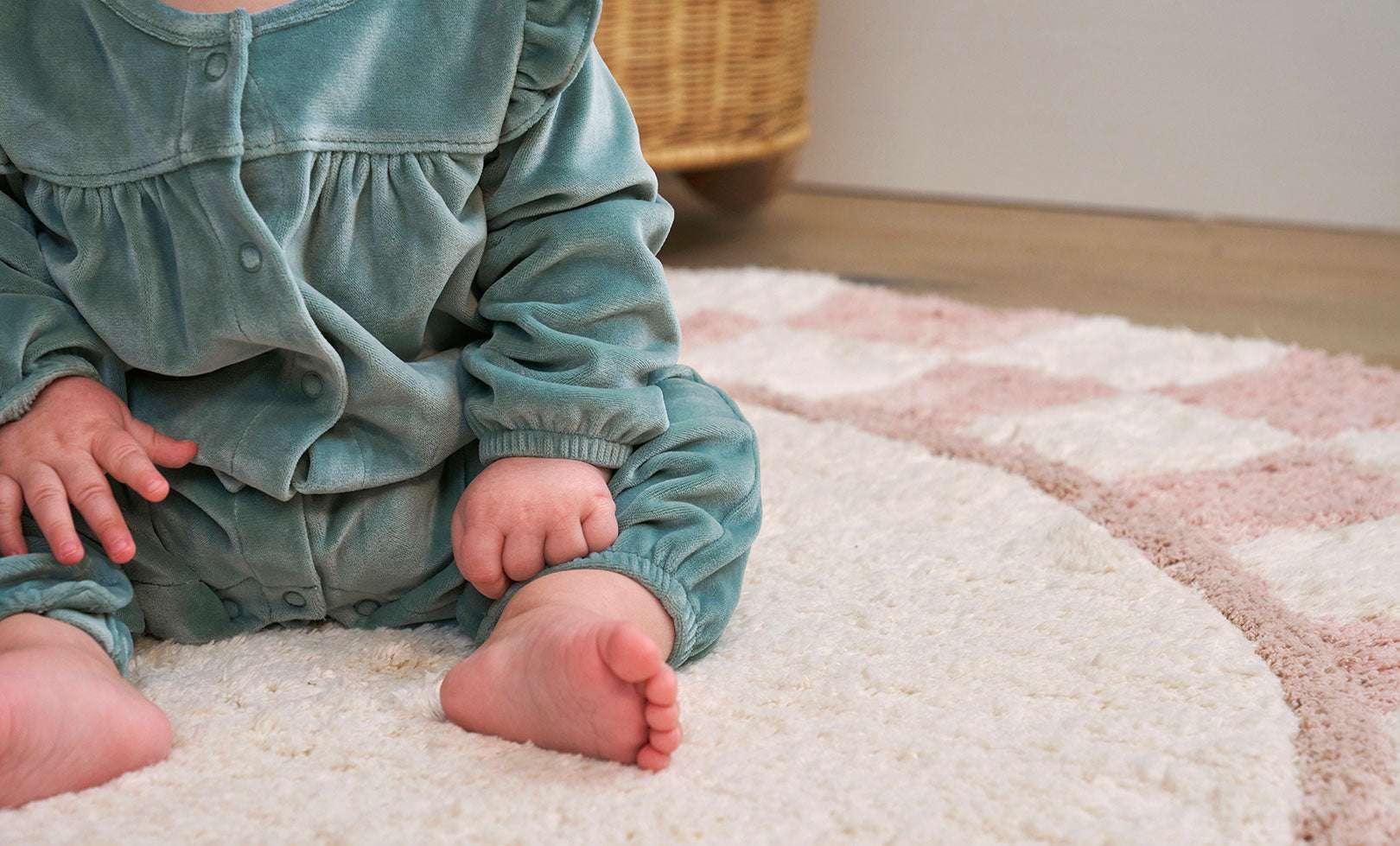 Chic pink checker rug made from organic fibers, combining soft hues with child-safe, machine-washable practicality.