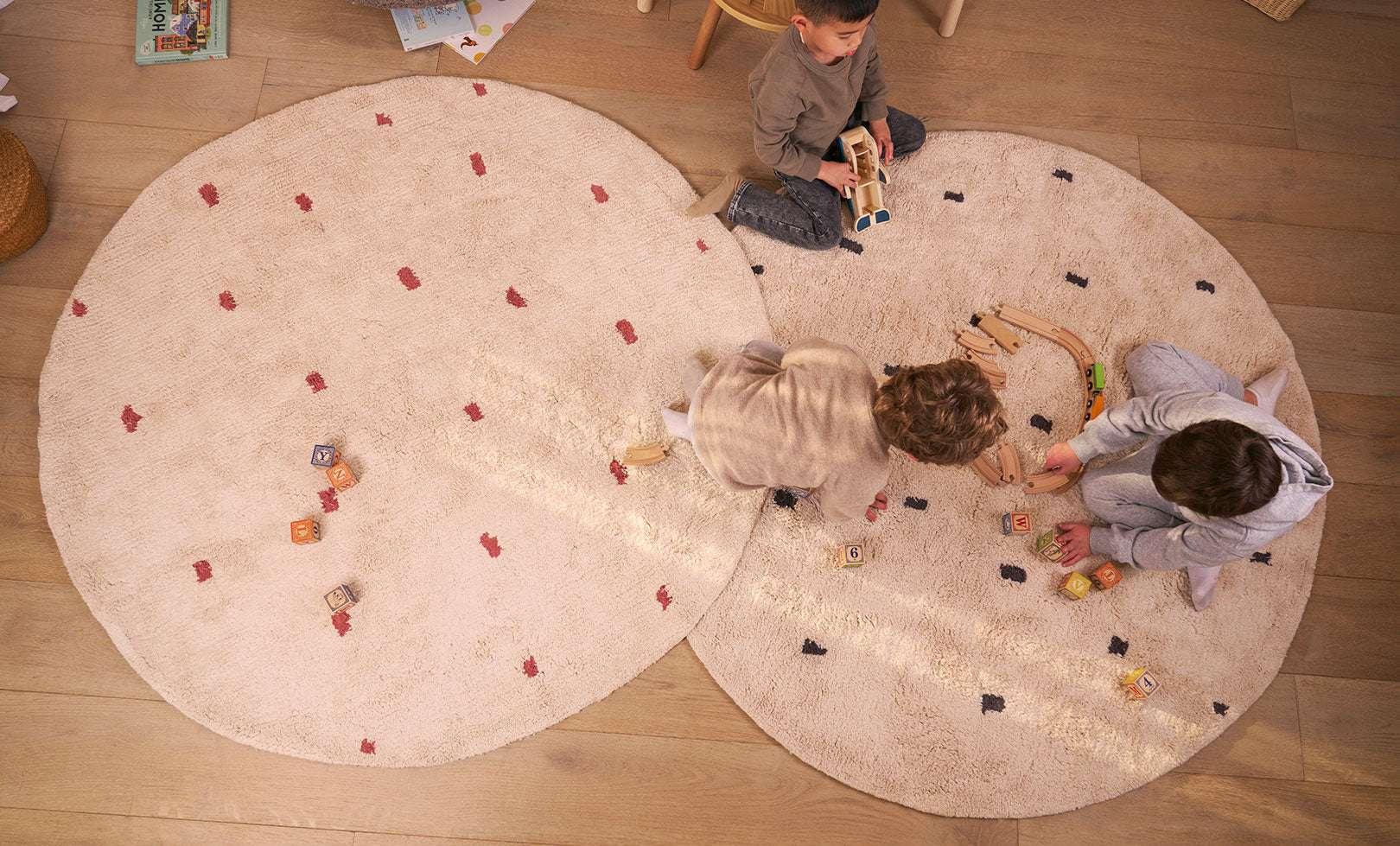Organic, washable nursery rug with a dotted rust design that combines earthy tones with child-safe materials.