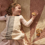Washable wool children’s rug featuring a pink pinwheel design, combining softness with playful charm.