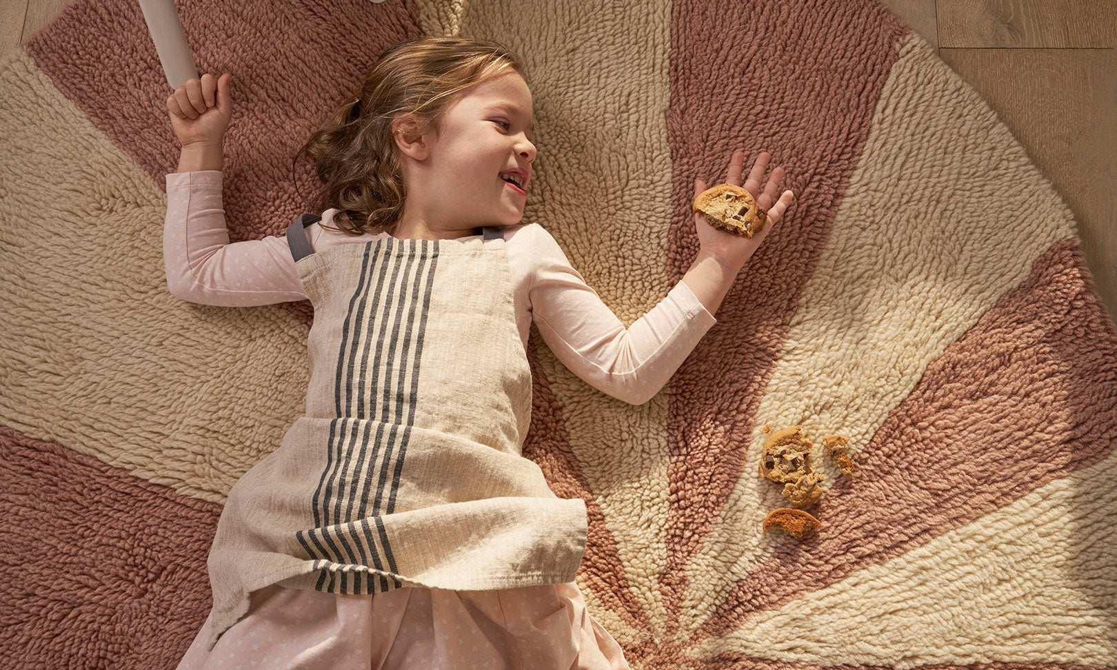 Washable wool children’s rug featuring a pink pinwheel design, combining softness with playful charm.