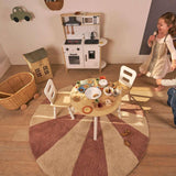 Washable wool children's rug featuring a pink pinwheel design, offering a cheerful and soft atmosphere for any room.